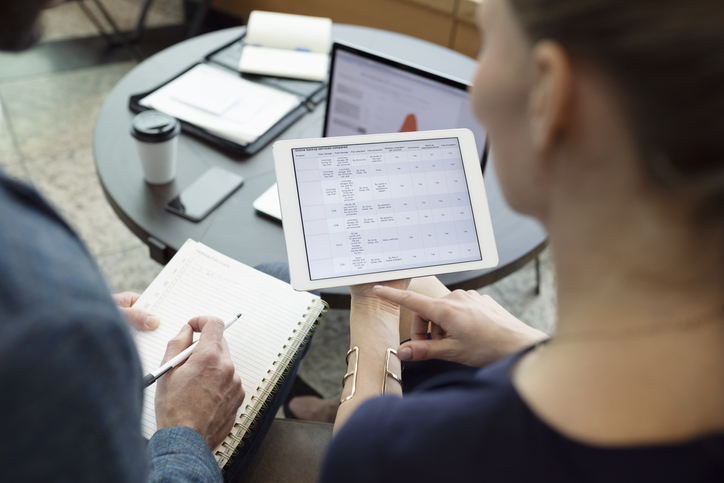 A woman and a man looking at an iPad. 