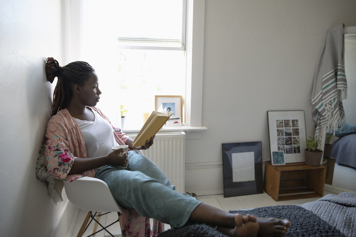 Woman reading book and drinking coffee