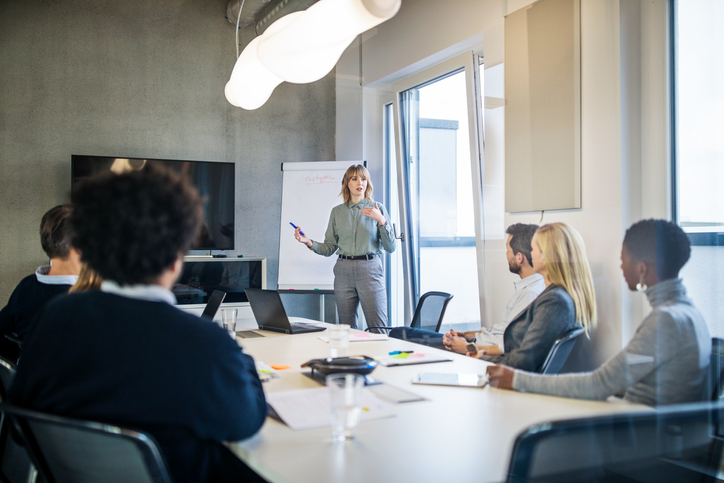 Woman presenting to group of people, presentation tools