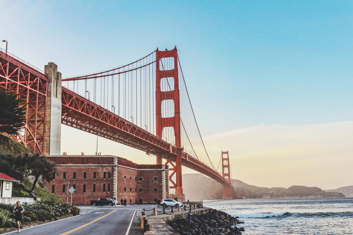 Lincoln Mitchell Golden Gate Bridge view from street level with a blue and yellow sky