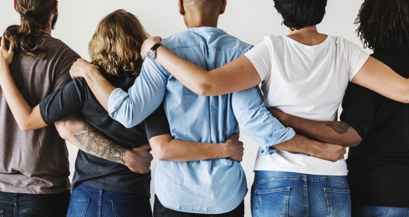 Diverse group of people holding one another in solidarity. Diverse group of people holding one another in solidarity.