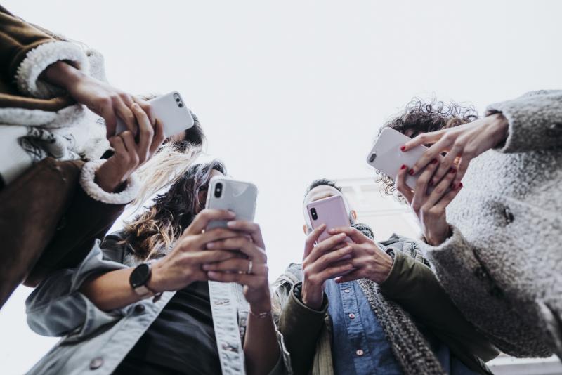 Ballot Measure - Digital Video Tips Digital video tips for your ballot measure - Four young adults standing in a circle looking at their phones.