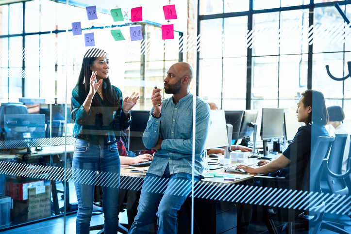 Campaign management -a male and female coworker discussing strategy in an office