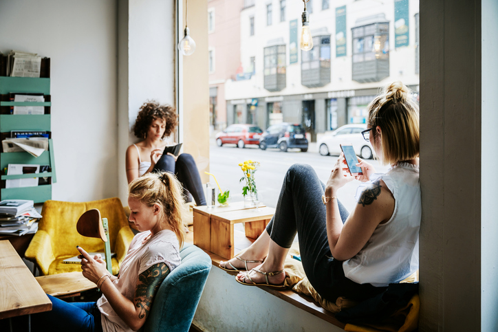 people on their phones and reading in a coffee shop