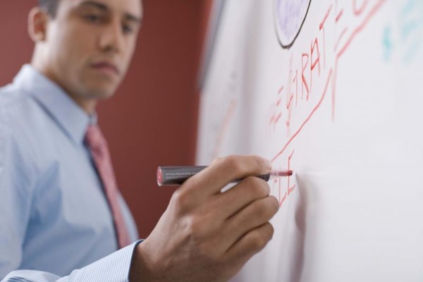 Man writing on whiteboard Campaign Plan 