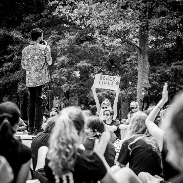 black and white colors, group of people at protest with girl holding up Black Lives Matter sign