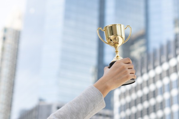 Person holding up gold trophy