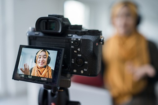 Young woman recording user-generated content with a camera.