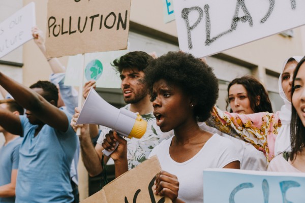 girl in protest crowd holding megaphone and sign