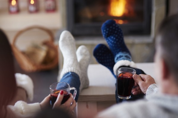 Picture of a couple sitting by the fire drinking holiday beverages