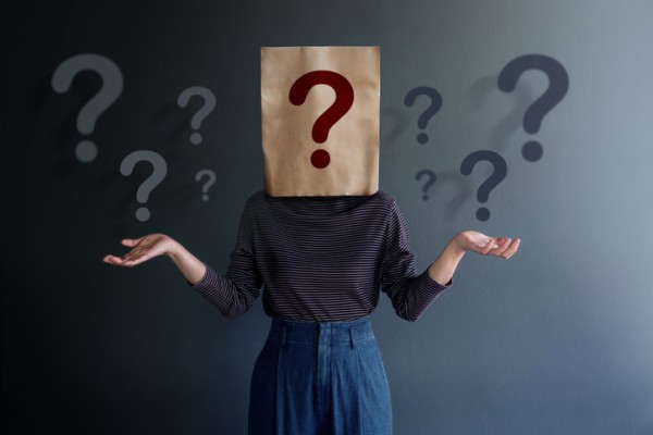 Picture of a woman with a paper bad over her head with a question