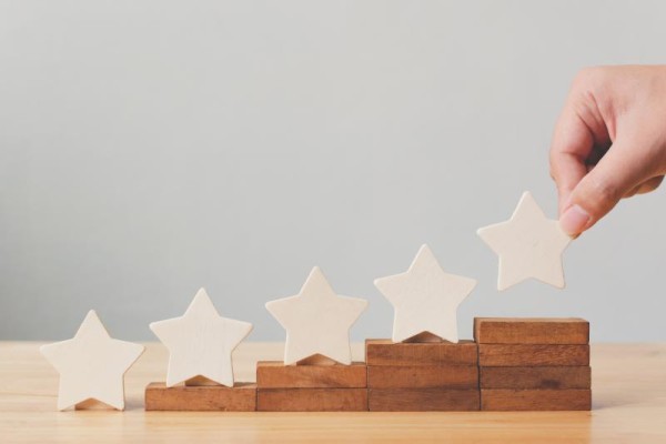 four wooden blocks in ascending height with white stars above the blocks. 