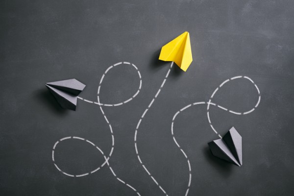 Ballot measure decisions : Three paper airplanes flying in different directions. Two are black and one is neon yellow.