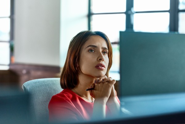 woman at desk staring into distance